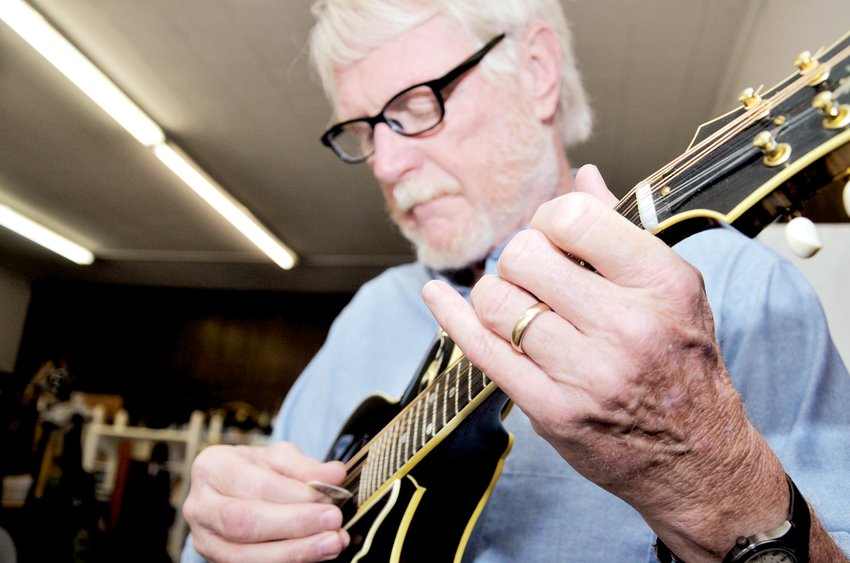 In this 2019 file photo, Tommy Edwards lays down a couple of riffs on the mandolin at his antiques, arts and music shop in Pittsboro. Edwards died Saturday at the age of 75 after a battle with pancreatic cancer.