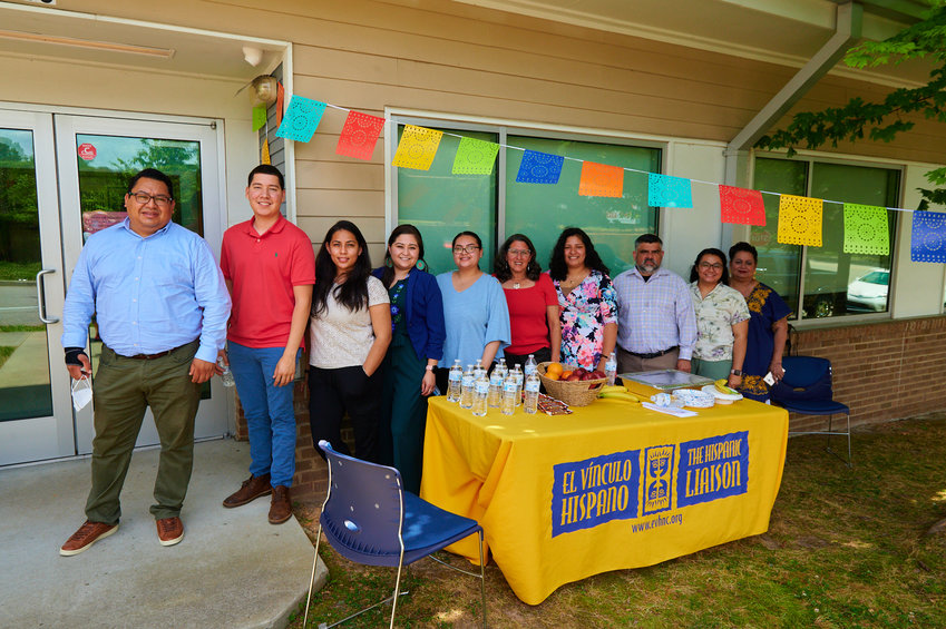 The Hispanic Liaison's staff, plus board vice chair Dennis Duke (third from right), pose in front of its new Sanford satellite office. The Liaison partnered with the Town of Siler City and the Building Integrated Communities project to survey the needs of Siler City's immigrant community in 2017.