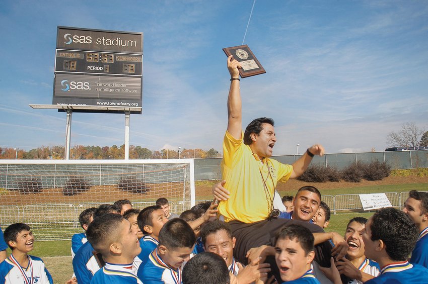 Jordan-Matthews Head Men's Soccer Coach Paul Cuadros is lifted up by his players after winning the 2004 NCHSAA 1A Men's Soccer State Championship, 2-0, over Lejune at SAS Soccer Park in Cary. Cuadros, author of 'A Home on the Field,' has been instrumental in bringing the Chatham 250 mobile exhibit honoring the creation of Los Jets and the 2004 title season to Chatham County Schools this fall.