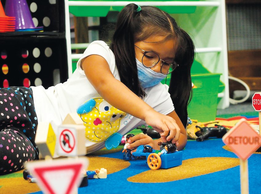 Andrea, a 4-year-old Pre-K student, creates a town with signs, animals and people at Bennett School on Monday morning.