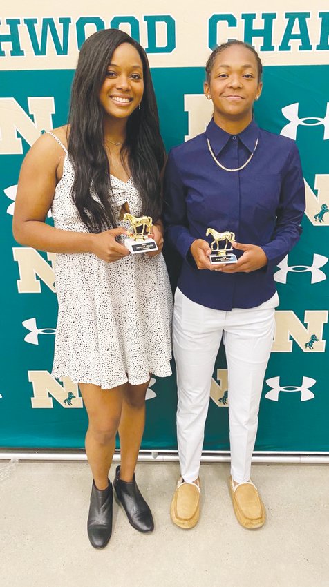 Northwood senior Olivia Porter (left), named Female Athlete of the Year, and sophomore Skylar Adams, who won the Women's Basketball Charlie award, pose with their Charlies during the Charlie Awards banquet on May 18.