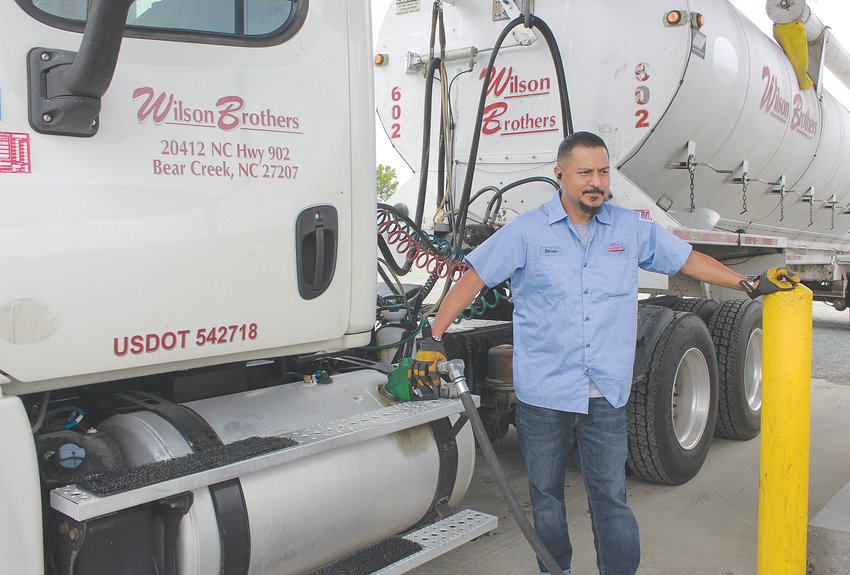 Wilson Brothers employee Darren Fiero pumps fuel into the tank of one of the company&rsquo;s trucks at the Wilson Brothers Milling and Trucking Co. yard Friday in Bear Creek.