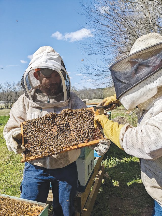 Mitchell Shivers (left) and his cousin Erik Simon tend to their hives at Three Dog Apiary, their beekeeping business in Pittsboro.