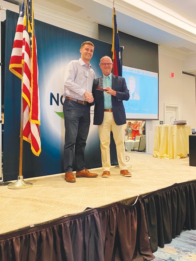 Sam Rauf (left) accepts the North Carolina Emerging Leader of the Year award from NCEDA President John Nelms at the NCEDA annual meeting in Wrightsville Beach. The award is given in recognition of the winner&rsquo;s contributions to expansions and projects completed during the previous calendar year.