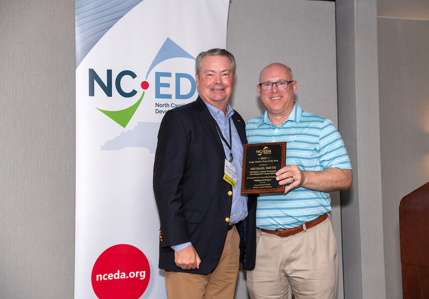 Michael Smith (left), president of Chatham County Economic Development Corporation, stands with Chris Plat&eacute;, president of North Carolina Economic Development Association (NCEDA), who holds Smith's plaque, recognizing his win of the 2023 Large Market Deal of the Year award during the NCEDA 2023 Annual Conference.