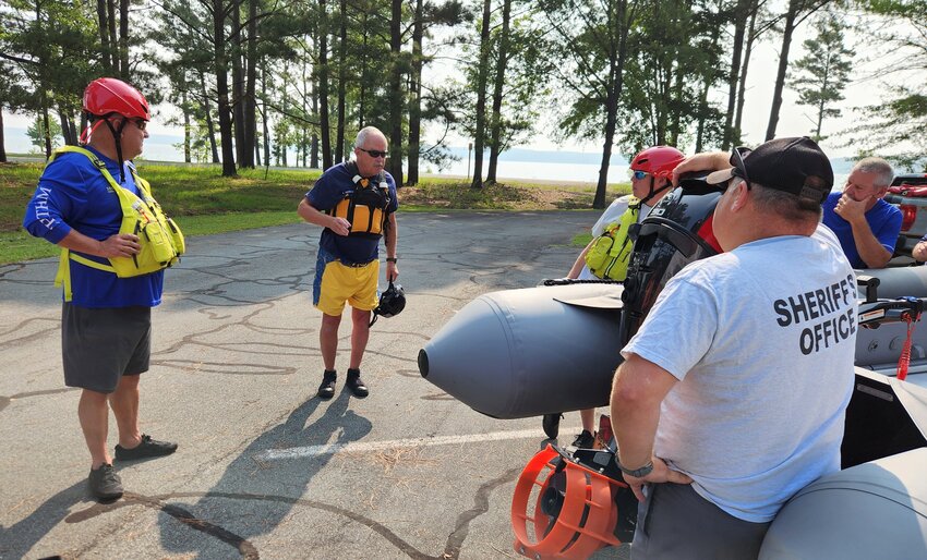 Lt. Eddie Freeman (second from left) of the North Chatham Fire Department briefs Sheriff Mike Roberson (left) and other Sheriff&rsquo;s Office personnel on the basics of operation of the inflatable Zodiac watercraft.