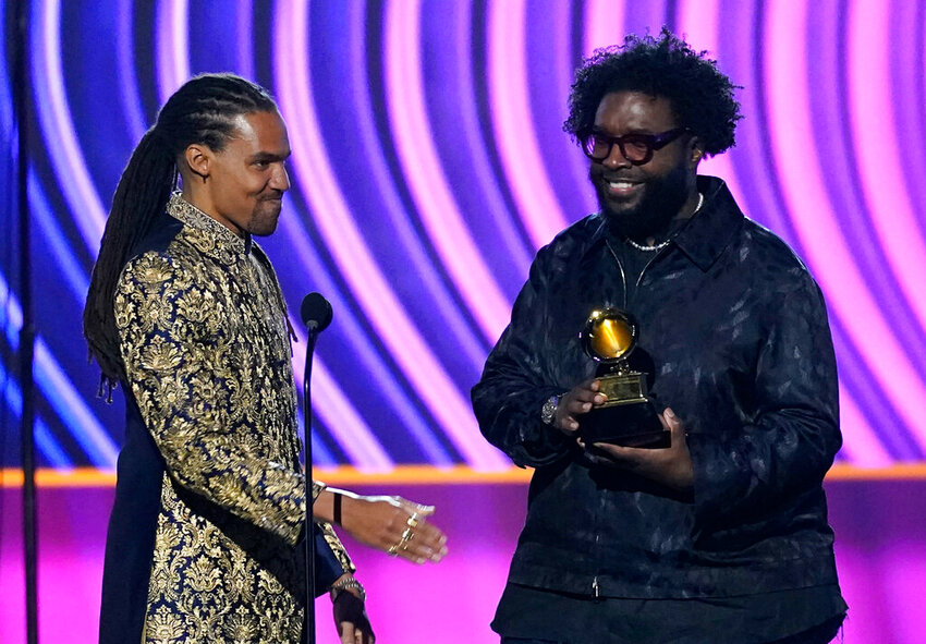 Pierce Freelon, left, presents the award for best music film album for &quot;Summer Of Soul&quot; to Questlove at the 64th Annual Grammy Awards on Sunday, April 3, 2022, in Las Vegas. (AP Photo/Chris Pizzello)