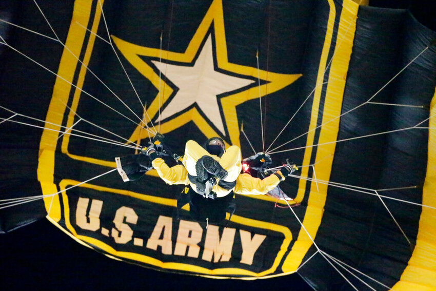 Members of the US Army Golden Knights parachute team glide into FedEx Filed before an NFL football game between the Washington Redskins and the New York Giants in Landover, Md., Thursday, Nov. 23, 2017. (AP Photo/Mark Tenally)