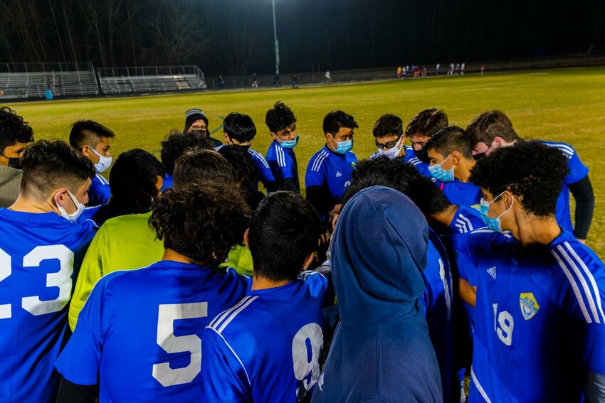 Giancarlo Aguila (19), shown here in a huddle as a freshman soccer player three years ago, is now trying a different type of football as a senior