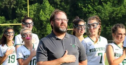 Cutline: Former Northwood women&rsquo;s lacrosse coach Larry Fritsche stands with his team during the national anthem before a game last season.