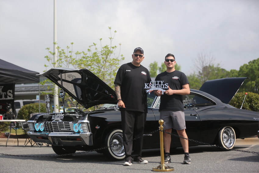 Daniel Casta&ntilde;eda, president of the City Knights Lowriders Car Club in Fayetteville, and his son Daniel stand in front of their 1967 Chevy Impala at the Lowrider Show, April 20 in Pittsboro.