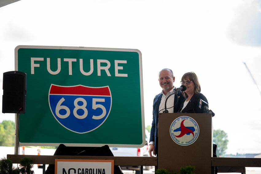 NC Transportation Board member Lisa Mathis and Transportation Secretary Joey Hopkins stand next to a Future I-685 sign.