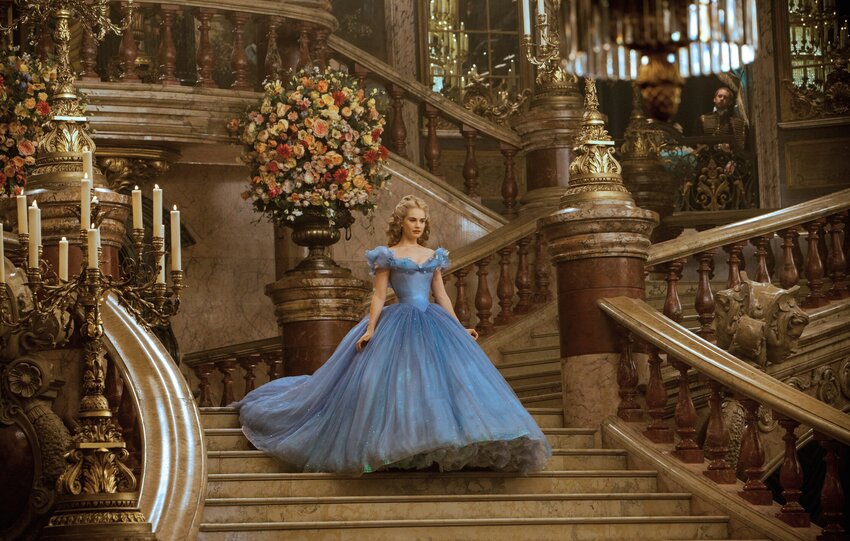 Lily James (as Cinderella) walks down a staircase in the movie Cinderella.