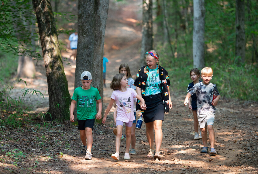 A camp counselor leads her group on a hike at Camp Kaleo in Forsyth, Ga., on July 18, 2023. (Index/Henry Durand, File)