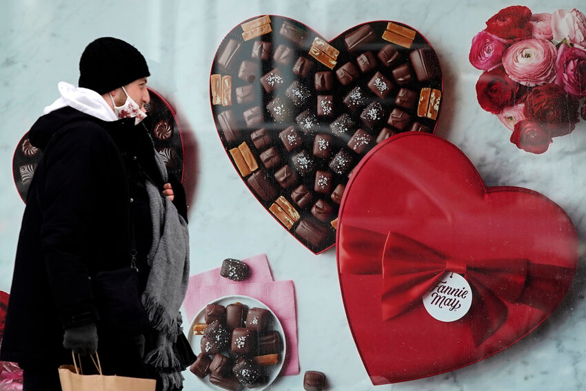 A man passes a Fannie May chocolate shop in downtown Chicago on Valentine's Day, Feb. 14, 2021. (AP Photo/Nam Y. Huh, File)