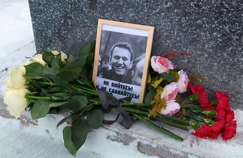Flowers and a portrait of Russian opposition leader Alexei Navalny that Lyudmila Navalnaya, mother of Russian opposition leader Alexei Navalny, put to pay tribute to her son at the memorial to victims of political repression, in Salekhard, Russia, on Tuesday, Feb. 20, 2024. (AP Photo)