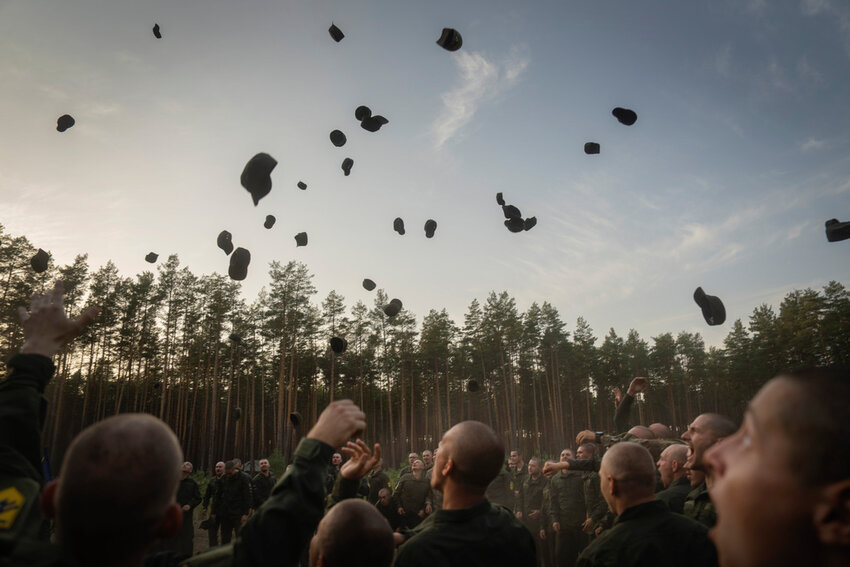 Newly recruited soldiers toss their hats as they celebrate the end of their training at a military base close to Kyiv, Ukraine, Monday, Sept. 25, 2023. (AP Photo/Efrem Lukatsky)