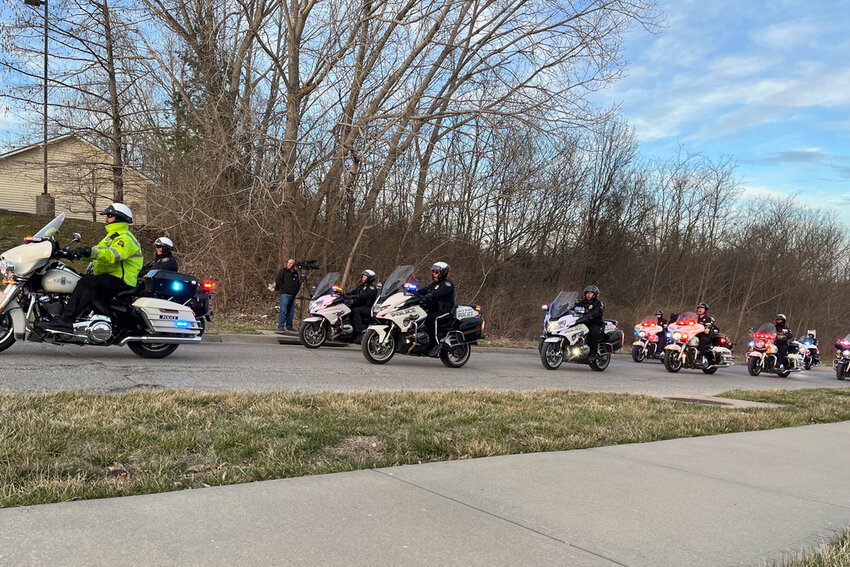 More than a dozen officers line up to escort the bodies of an Independence, Mo., police officer and a Jackson County court worker to the medical examiner's office Thursday, Feb. 29, 2024, in Independence. (AP Photo/Heather Hollingsworth)