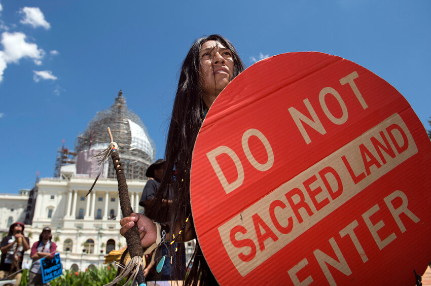 FILE - An Apache activist dancer performs in a rally to save Oak Flat, land near Superior, Ariz., sacred to Western Apache tribes, in front of the U.S. Capitol in Washington, Tuesday, July 22, 2015. An Apache group that has fought to protect land it considers sacred from a copper mining project in central Arizona suffered a significant blow Friday, March 1, 2024, when a divided federal court panel voted 6-5 to uphold a lower court's denial of a preliminary injunction to halt transfer of land for the project. (AP Photo/Molly Riley, File)