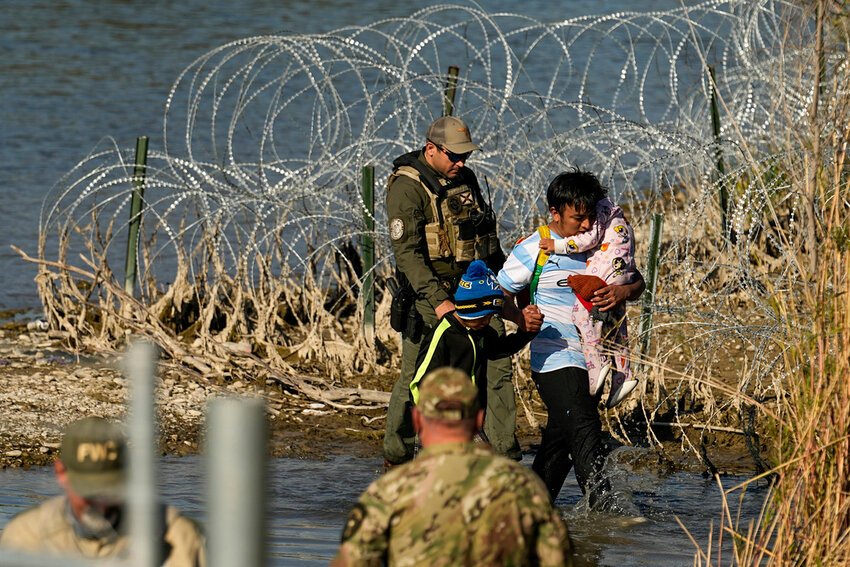 Migrants are taken into custody by officials at the Texas-Mexico border, Jan. 3, 2024, in Eagle Pass, Texas. (AP Photo/Eric Gay, file)