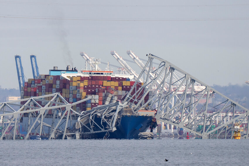 Wreckage of the Francis Scott Key Bridge rests on a container ship Tuesday, March 26, 2024, as seen from Pasadena, Md. (AP Photo/Mark Schiefelbein)