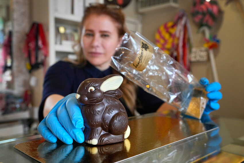 Niaz Mardan wraps a luxury handmade Belgian chocolate rabbit at Sandrine a chocolate shop in southwest London, Thursday, March 21, 2024. (AP Photo/Kirsty Wigglesworth)
