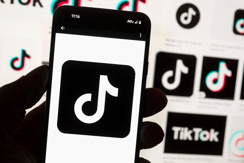 The TikTok logo is seen on a mobile phone in front of a computer screen which displays the TikTok home screen, Oct. 14, 2022, in Boston. (AP Photo/Michael Dwyer, File)