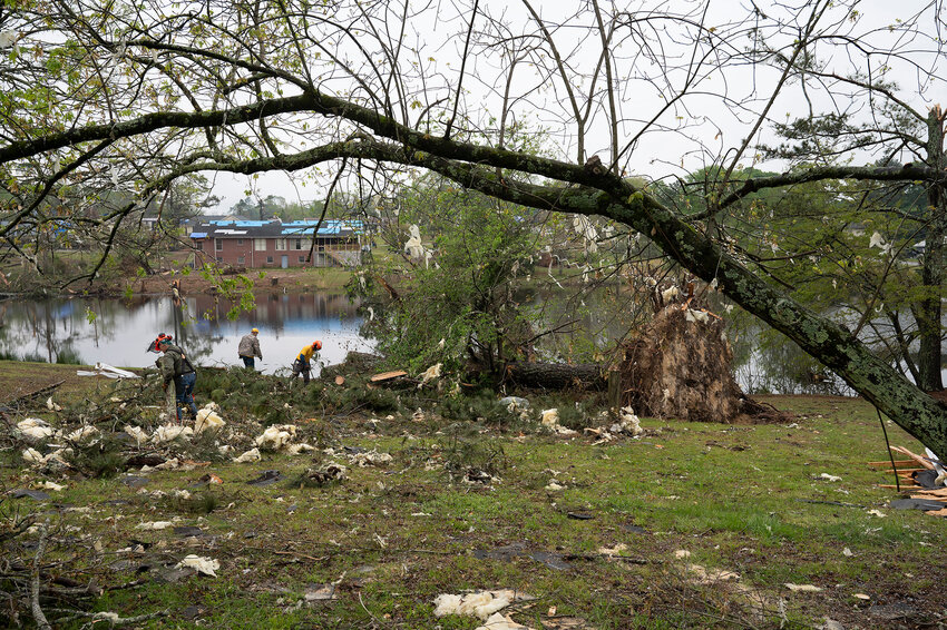 Georgia Baptist Disaster Relief volunteers work to clear fallen trees and torn insulation from a yard in Conyers, Ga., Tuesday, April 9, 2024, after an EF-2 tornado struck last week. (Index/Henry Durand)