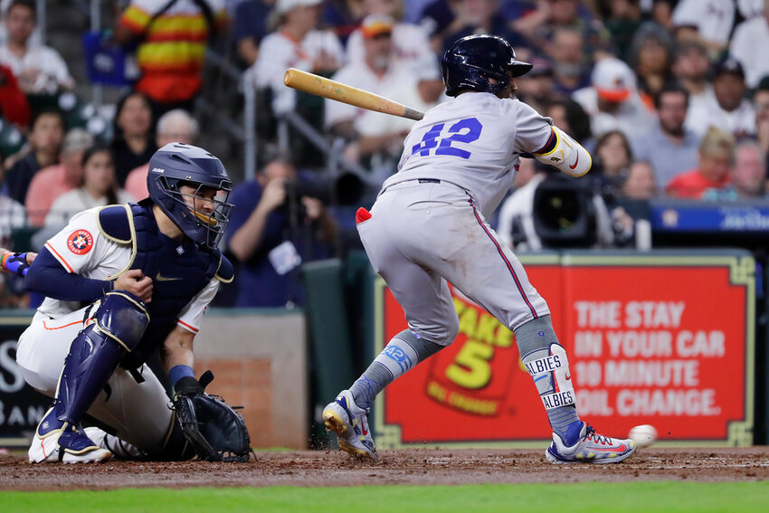 With the bases loaded, Atlanta Braves batter Ozzie Albies, right, is hit in the foot by a pitch in front of Houston Astros catcher Yainer Diaz, left, allowing the Braves' second run during the second inning Monday, April 15, 2024, in Houston.  (AP Photo/Michael Wyke)