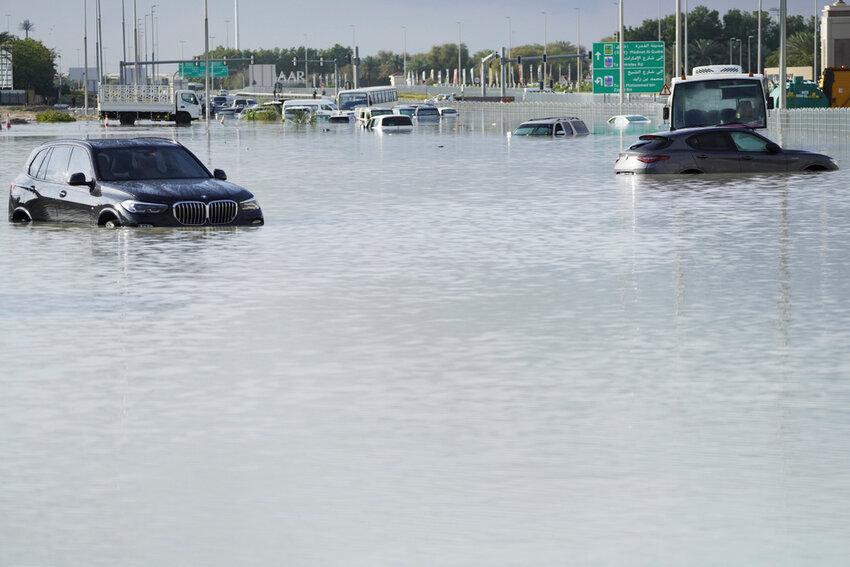 Vehicles sit abandoned in floodwater covering a major road in Dubai, United Arab Emirates, Wednesday, April 17, 2024. (AP Photo/Jon Gambrell)