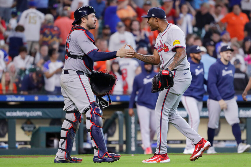Atlanta Braves catcher Travis d'Arnaud, left, and closing pitcher Raisel Iglesias celebrate after defeating the Houston Astros, Wednesday, April 17, 2024, in Houston. The Braves won 5-4 in 10 innings.  (AP Photo/Michael Wyke)
