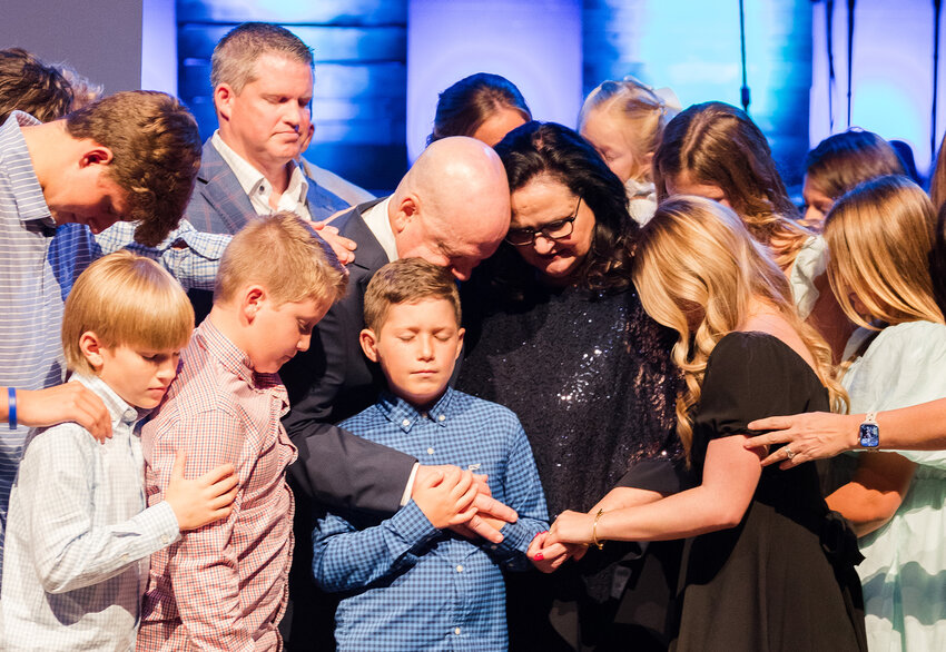 The Akin family prays during a celebration of the Akins' 20 years of service to Southeastern Seminary. (SEBTS/Rebessa Hankins)