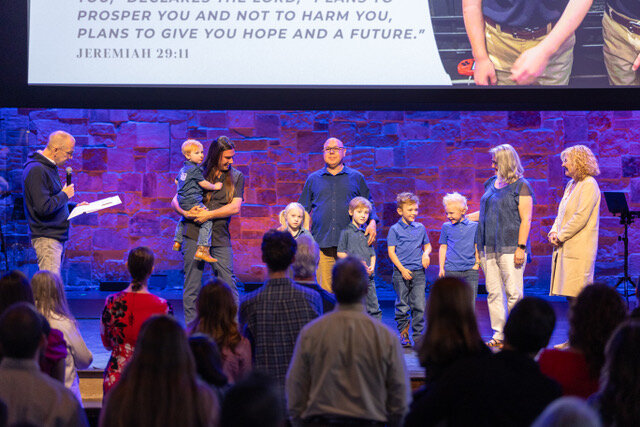 Eastside Pastor John Hull, left, highlights the commitment of Darrell and Shelly Whipple to the principle of adoption care. (Photo/Eastside Baptist Church)