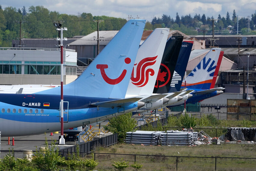 Boeing 737 Max airplanes, including one belonging to TUI Group, left, sit parked at a storage lot, Monday, April 26, 2021, near Boeing Field in Seattle.  (AP Photo/Ted S. Warren, File)