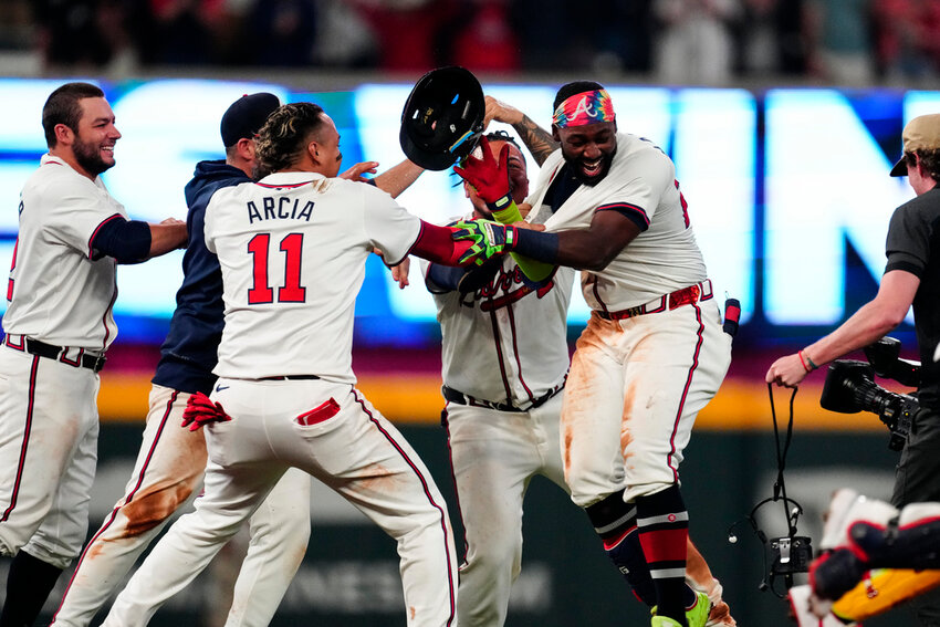 Atlanta Braves' Michael Harris II, right, is mobbed by teammates after driving in the game-winning run with a double in the 10th inning against the Miami Marlins on Wednesday, April 24, 2024, in Atlanta. (AP Photo/John Bazemore)