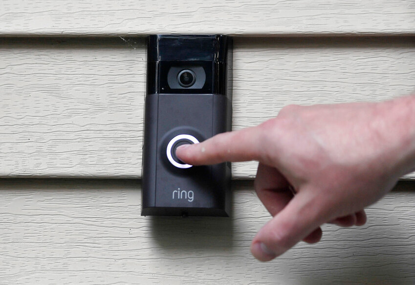 A person pushes the doorbell on his Ring doorbell camera, July 16, 2019, at his home in Wolcott, Conn. (AP Photo/Jessica Hill, File)