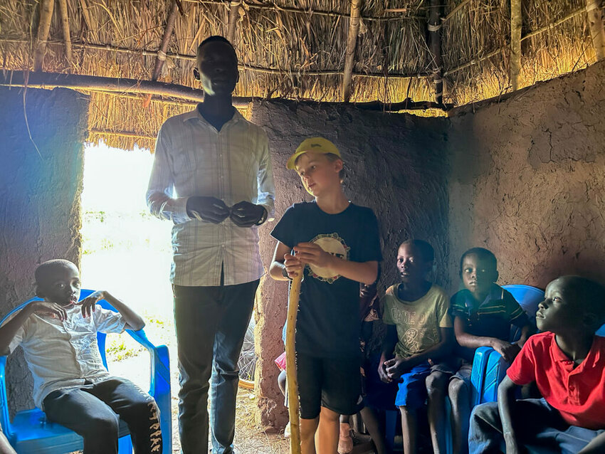 Micah Singerman, IMB missionary kid, tells the story of David and Goliath to children in a Ugandan village. (Photo/IMB)