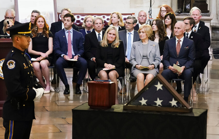 Jean Puckett, seated in foreground center, wife of retired Army Col. Ralph Puckett Jr., sits with her children, Martha Puckett, left, and Thomas Puckett, right, during a lying in honor ceremony for Puckett Jr. at the Capitol in Washington, Monday, April 29, 2024. Puckett Jr. (Shawn Thew/Pool Photo via AP)