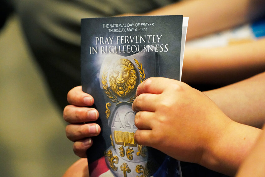 An attendee of a National Day of Prayer gathering at the Mississippi Coliseum in Jackson, holds a program Thursday, May 4, 2023. (AP Photo/Rogelio V. Solis, File)