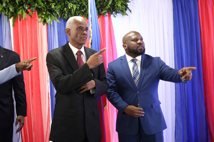 Edgard Leblanc Fils, left, and Smith Augustin prepare to pose for a group photo with the transitional council after it named Fils as its president in Port-au-Prince, Haiti, Tuesday, April 30, 2024. (AP Photo/Odelyn Joseph)
