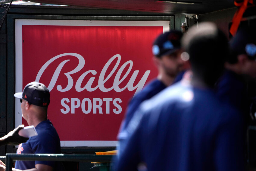 A Bally Sports sign hangs in a dugout before the start of a spring training game between the St. Louis Cardinals and Houston Astros, Thursday, March 2, 2023, in Jupiter, Fla. (AP Photo/Jeff Roberson, File)