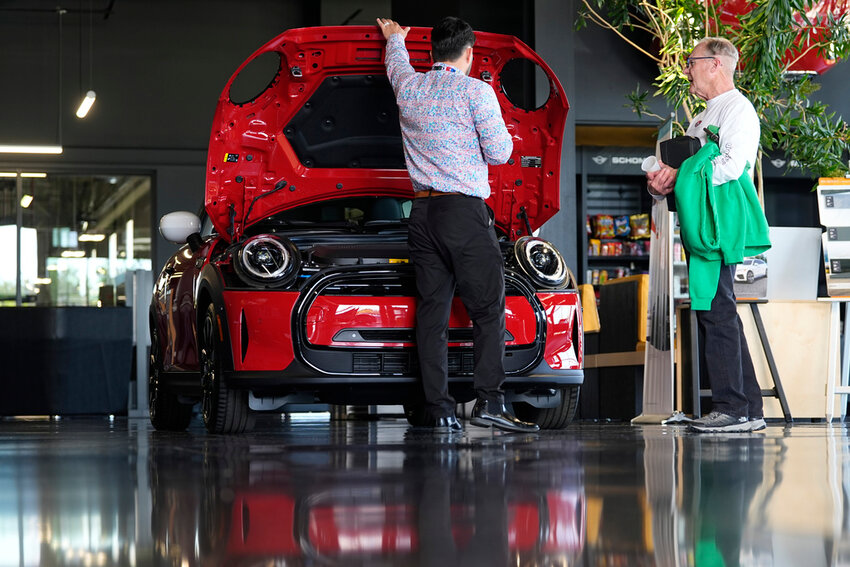 A salesperson shows an unsold 2024 Cooper SE electric hardtop to a prospective buyer at a Mini dealership Wednesday, May 1, 2024, in Highlands Ranch, Colo. (AP Photo/David Zalubowski)