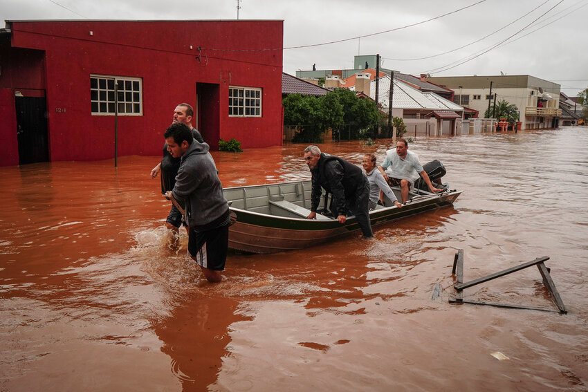 People evacuate a flooded area after heavy rain in Sao Sebastiao do Cai, Rio Grande do Sul state, Brazil, Thursday, May 2, 2024. (AP Photo/Carlos Macedo)