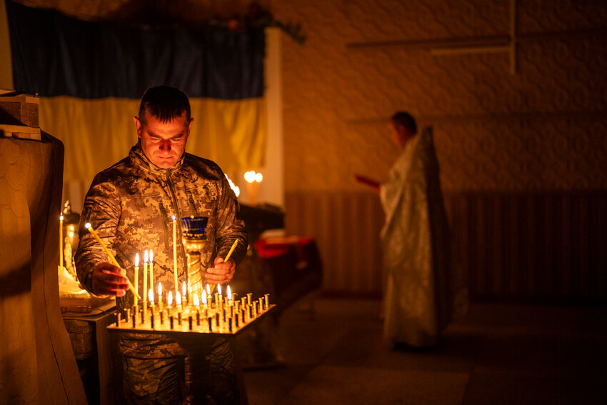 An Ukrainian serviceman lights candles during an Orthodox Easter service in Donetsk region, Ukraine, Saturday, May 4, 2024. (AP Photo/Francisco Seco)