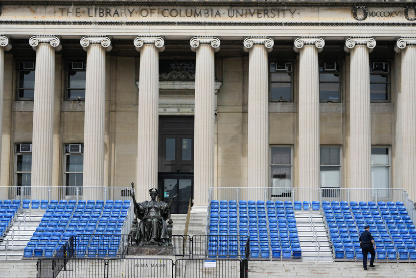 A New York City police officer walks past seating that was to be used for a large graduation ceremony at Columbia University in New York, Monday, May 6, 2024. (AP Photo/Seth Wenig)