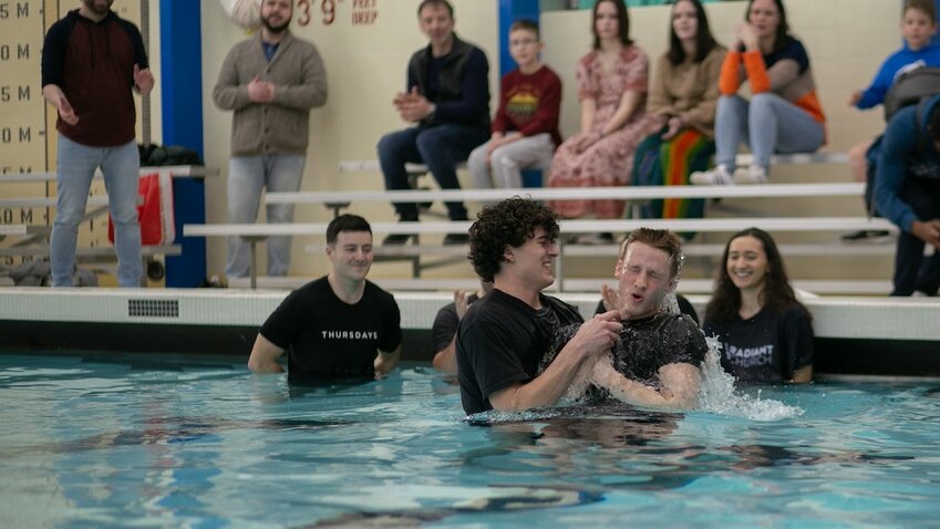 Daniel Lamar baptizes a believer during a Radiant Church baptism service held at a local swimming pool. Radiant Church in Syracuse, N.Y. was planted in 2023 and has a special emphasis on reaching college students as well as the wider Syracuse community. (Photo/Radiant Church via NAMB)