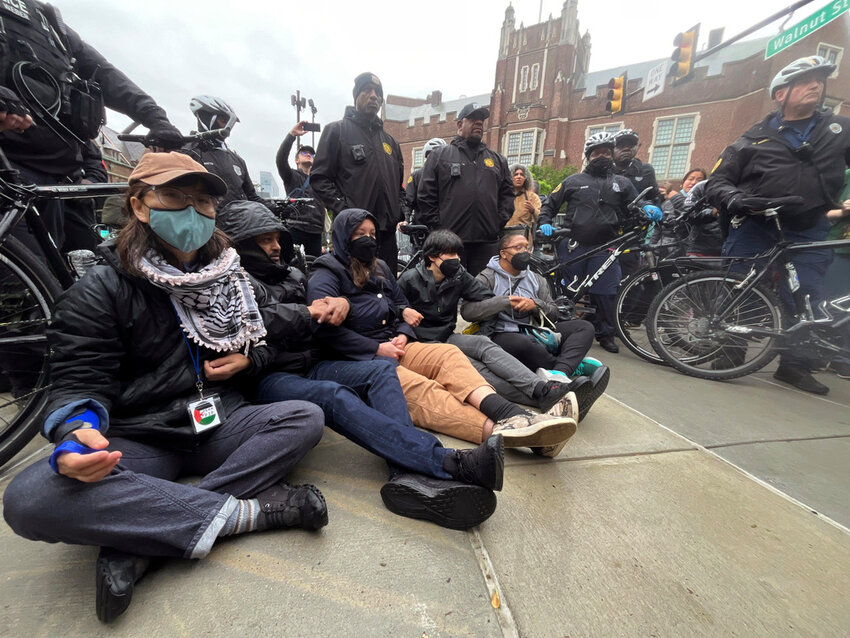 Protesters lock arms as police clear an encampment of pro-Palestinian demonstrators at the University of Pennsylvania in Philadelphia, Friday, May 10, 2024. (Jessica Griffin/The Philadelphia Inquirer via AP)