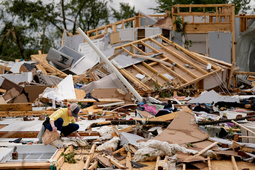 Valerie Bernhardt looks through debris of her destroyed home home Thursday, May 9, 2024, in Columbia, Tenn. (AP Photo/George Walker IV)