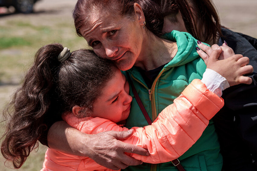 Khrystyna Pyimak, 11, hugs her mother Oksana Velychko, 42, after evacuation from Vovchansk, Ukraine, Sunday, May 12, 2024. Her husband was killed in their house after a Russian airstrike on the city. (AP Photo/Evgeniy Maloletka)