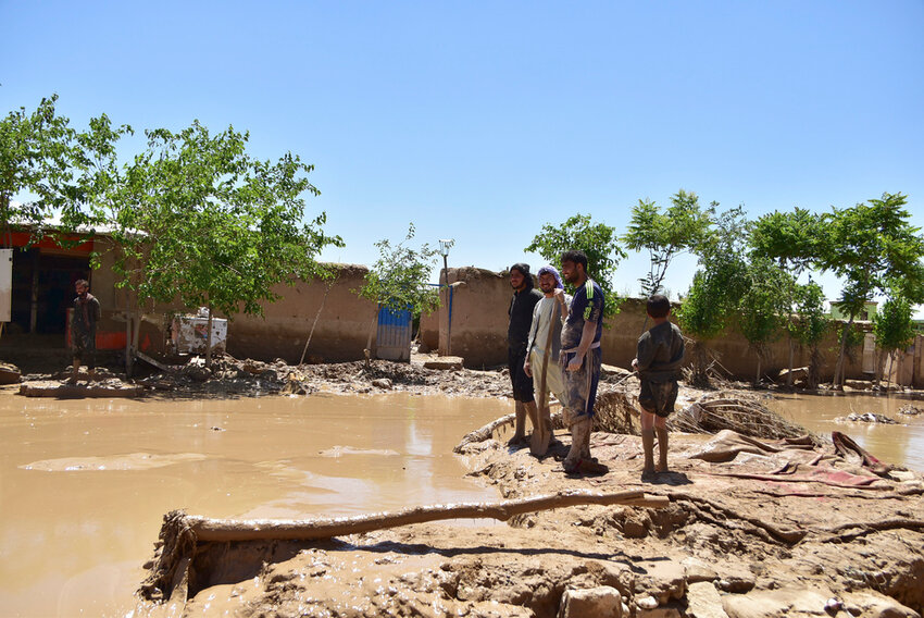 People stand near damaged homes after heavy flooding in Baghlan province, in northern Afghanistan, Sunday, May 12, 2024. (AP Photo)